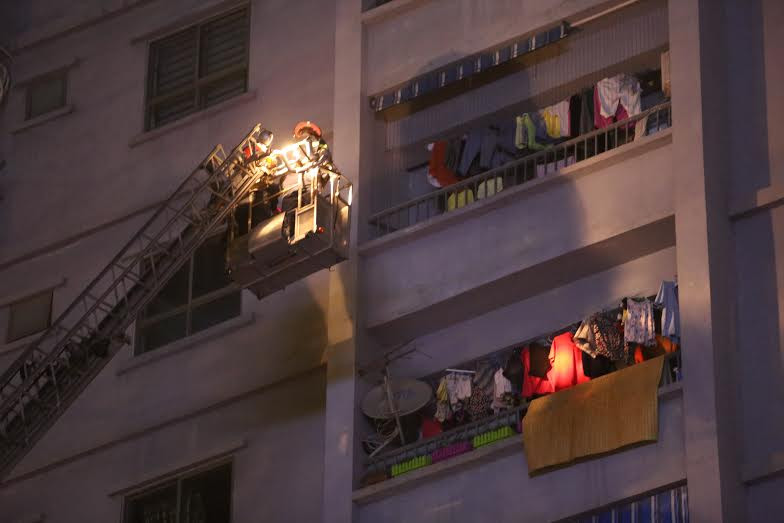 Lực lượng chức năng dùng thang cứu hộ những người mắc kẹt bên trên.