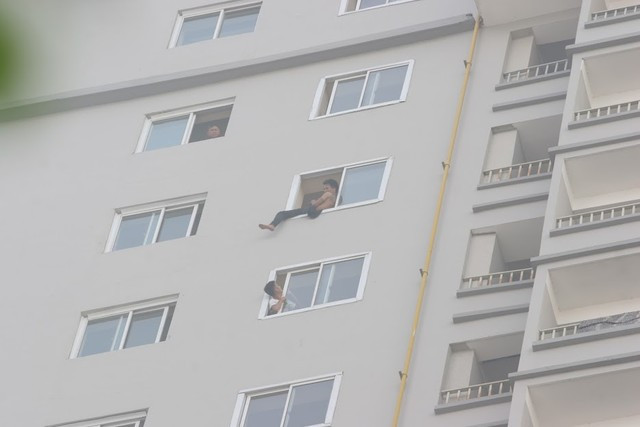 Lực lượng chức năng cho người canh chừng ở tầng 20, ngăn không cho nam thanh niên nhảy xuống. Ảnh: Dân Trí