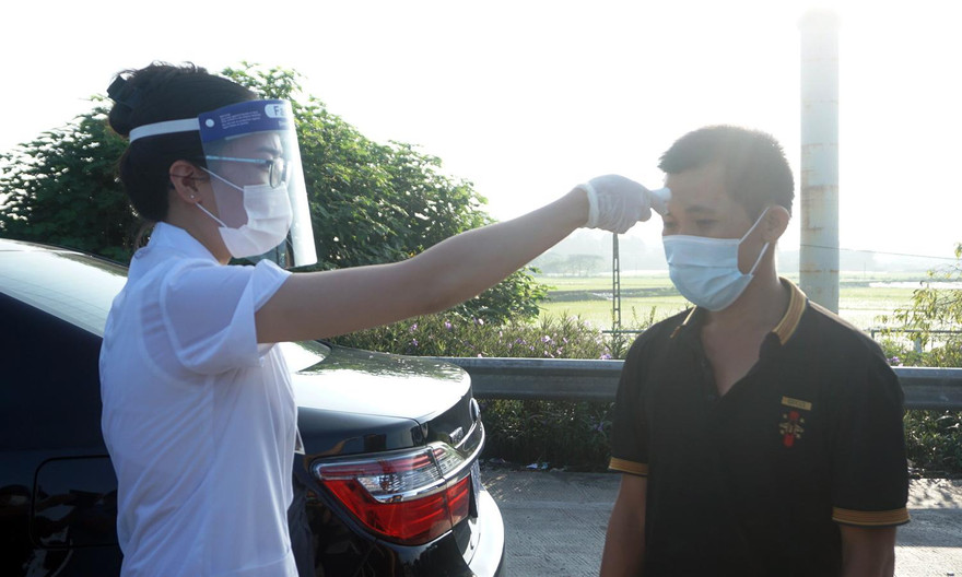 Lực lượng y tế kiểm tra thân nhiệt lái xe tại chốt kiểm soát dịch.