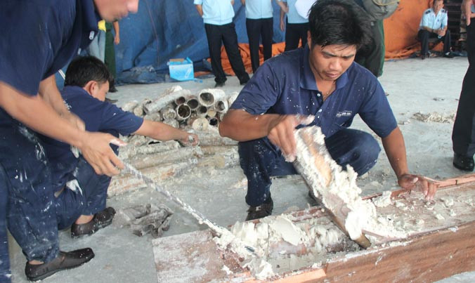 Lực lượng chức năng tiến hành kiểm tra lô hàng gỗ chứa ngà voi. 