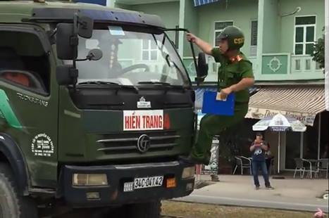 Tài xế vẫn điều khiển cho xe chạy mặc dù cảnh sát đang đu bám trước mũi xe (ảnh cắt từ clip)