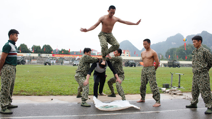 Trinh sát đặc nhiệm Quân khu 1 biểu diễn màn nội công nhảy từ trên cao xuống đám mảnh chai sắc nhọn.