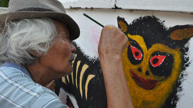 Cụ Đức say sưa vẽ cho đình làng bức tranh "Long chầu hổ phục".