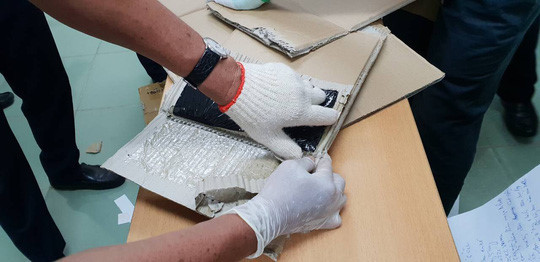 Lực lượng chức năng phải cạy miếng carton mới lấy được số thuốc lắc được giấu tinh vi