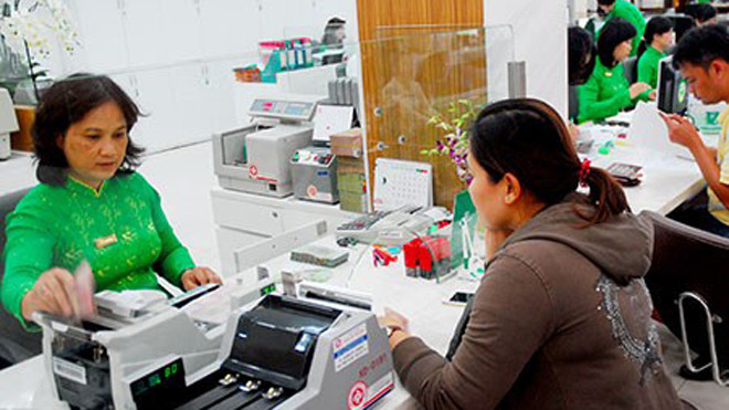 Khách hàng đang giao dịch tại một ngân hàng ở TP.HCM. Ảnh: HTD