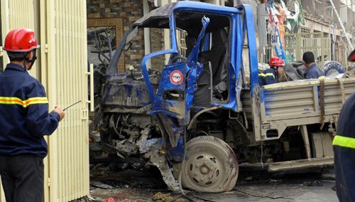 Lực lượng cứu hộ đang giải cứu lái xe Đặng Cao Thủy ra khỏi chiếc xe tải 29C-477.58 bị bẹp dúm cabin do đâm vào tường nhà.