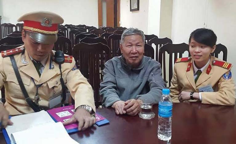 Các chiến sĩ CSGT đưa cụ ông đi lạc về trụ sở tìm cách đưa cụ về nhà.