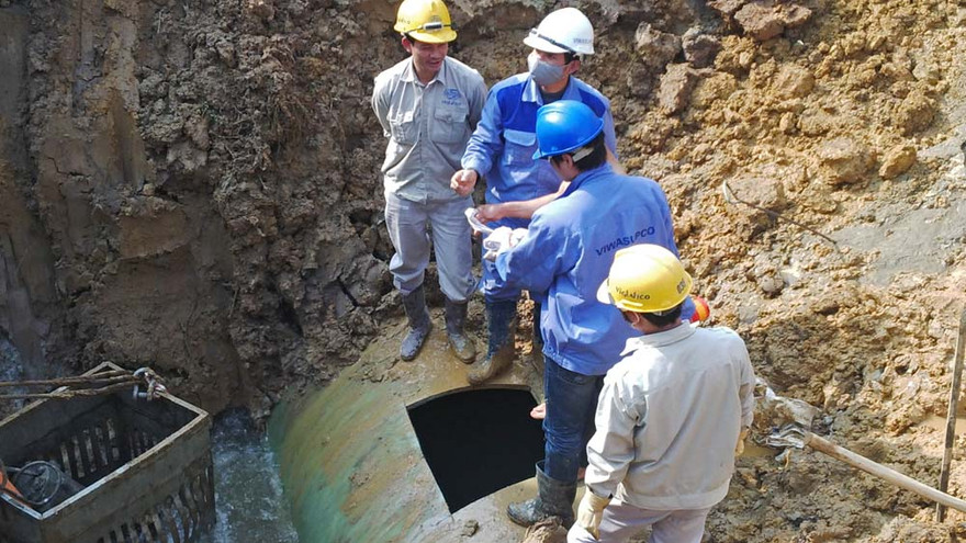 Các công nhân tiến hành cắt đường ống và vào bên trong để tìm điểm bị vỡ. Ảnh: Thanh Hà.