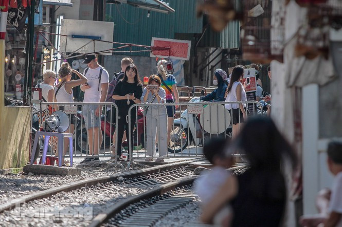 Du khách đứng ngoài rào chắn để chụp ảnh. Ảnh Như Ý