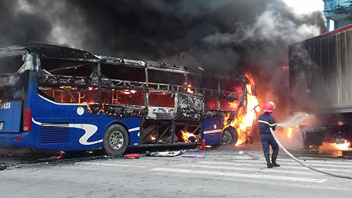 Ngọn lửa bao trùm thân xe khách và đầu container. Ảnh: Lê Hoàng.