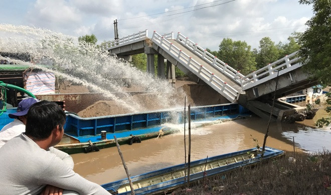 Bơm nước để giải cứu xà lan bị kẹt