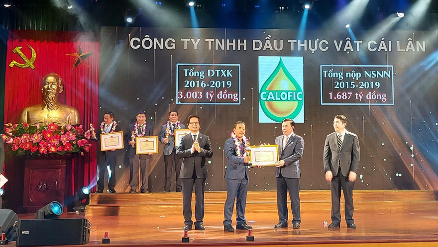 Bộ trưởng Bộ Tài chính Đinh Tiến Dũng và Tổng cục trưởng Tổng cục Thuế trao bằng khen cho 30 doanh nghiệp nộp thuế tiêu biểu. Ảnh: Tuấn Nguyễn