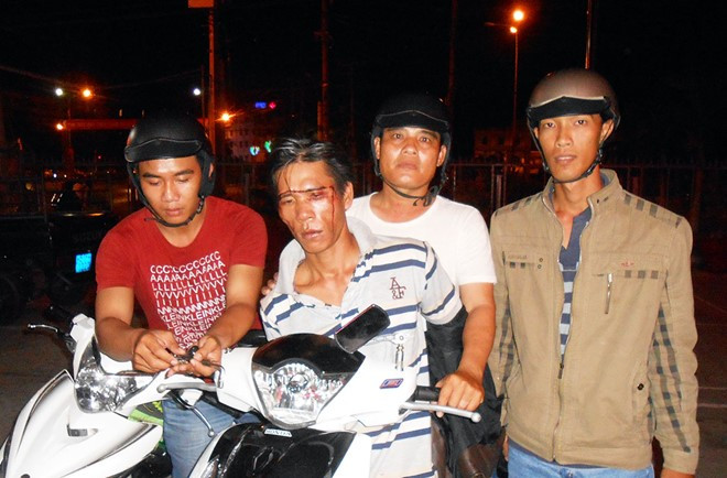 Nguyễn Văn Sinh (không đội mũ bảo hiểm) bị các "hiệp sĩ" Bình Dương khống chế. Ảnh: Thanh Hải