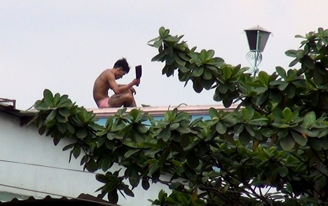 Nam thanh niên nghi ngáo đá cầm dao cố thủ trên sân thượng. Ảnh: Thái Linh