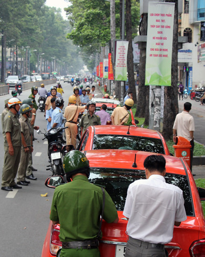 Loạt ôtô đậu vỉa hè đường Trần Hưng Đạo bị xử lý. Ảnh: Duy Trần.