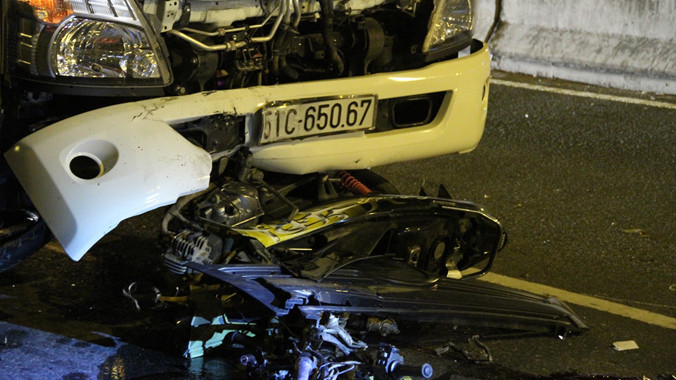 Chiếc xe máy dính chặt dưới đầu xe tải.