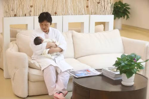 Cô béLittle Bawan trong vòng tay mẹ. Ảnh:Straitstimes.
