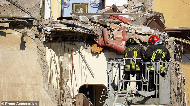 Hai lính cứu hỏa làm việc tại hiện trường vụ sập nhà. Ảnh: AP