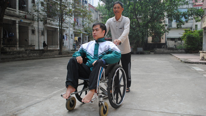 Hằng ngày, Bách tới giảng đường trên đôi chân của cha. Ảnh: Duy Ngợi.