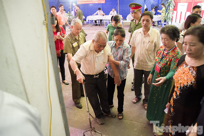 Cử tri Bùi Văn Tài đi xe lăn đến điểm bầu cử bỏ phiếu.