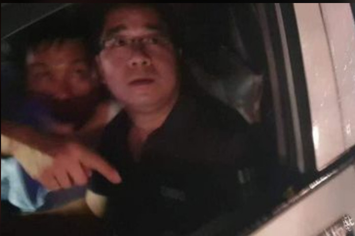 Hình ảnh hai người đàn ông trên chiếc ô tô.