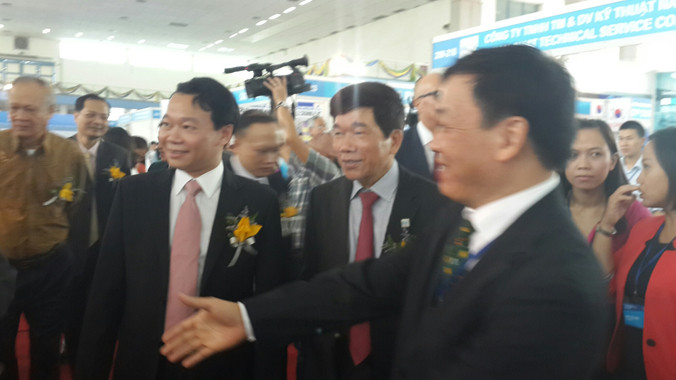 Thứ trưởng Bộ Xây dựng Đỗ Đức Duy (bên trái, veston đen) đi thăm gian hàng trưng bày tại triển lãm.