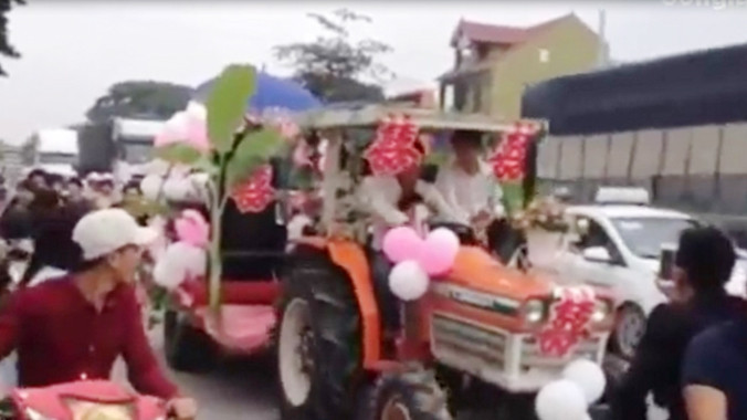 Chiếc máy cày được trang trí thành xe hoa “đại náo” quốc lộ 1 A. (Ảnh cắt từ clip).
