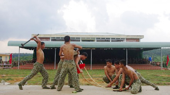 Chiến đấu viên vận khí công dùng yết hầu bẻ cong cây thương và đập tấm bê tông 45 kg trên lưng.