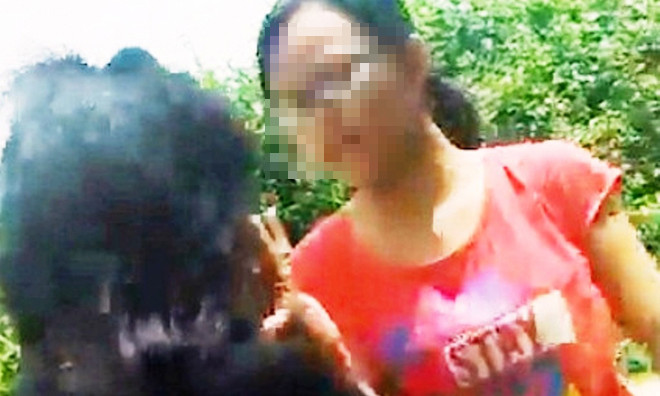 Bé gái mặc áo đỏ chặn đánh bạn cùng trang lứa ngay giữa đường.