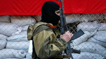 Một tay súng ly khai canh gác bên ngoài văn phòng thị trưởng ở Slaviansk - Ảnh: Reuters 