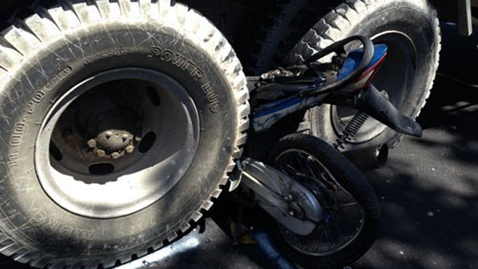Xe máy nằm gọn giữa hai bánh xe.