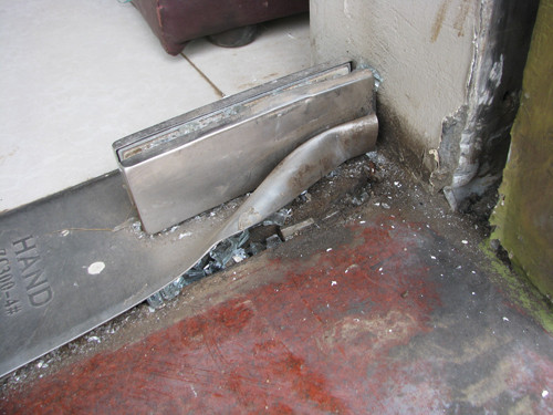 Hiện trường vụ nổ mìn làm hỏng cửa cuốn, vỡ cửa kính. Ảnh: Minh Cương