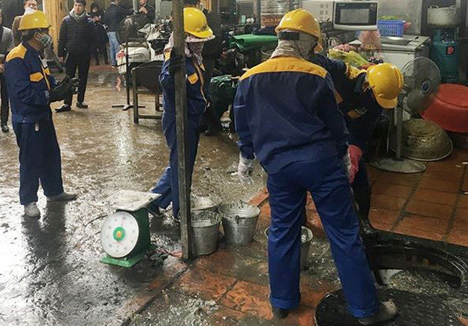 Tiến hành thu gom váng cặn dầu mở được tách từ nước thải một cửa hàng ăn uống. Ảnh Trọng Đảng