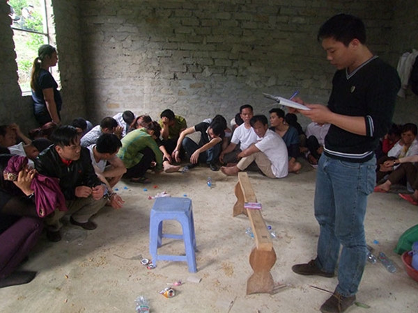 Các con bạc bị bắt giữ và Cảnh sát cơ động áp giải các đối tượng đánh bạc.