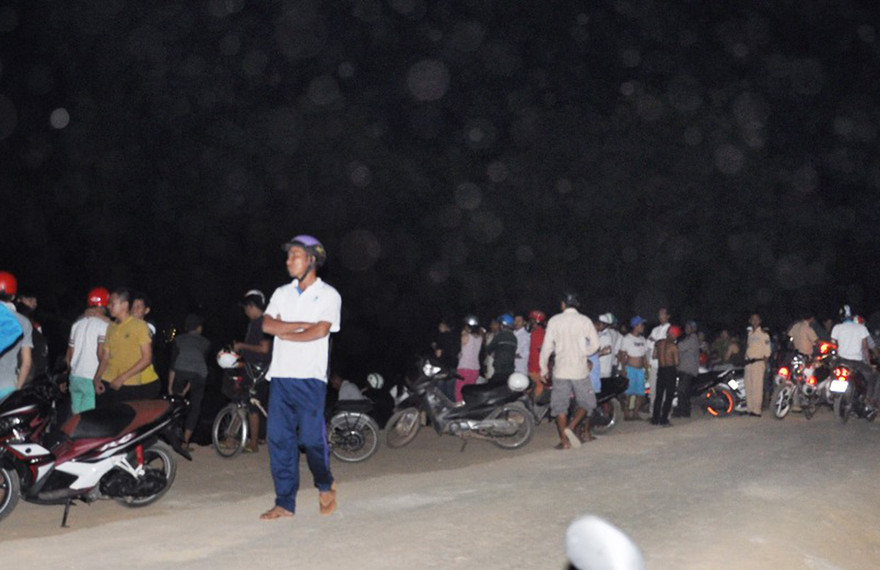 Người dân tụ tập bên hồ dõi theo công tác khám nghiệm hiện trường.