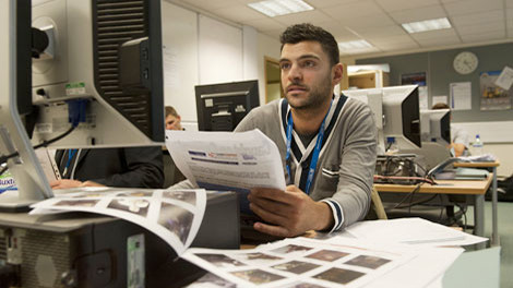 Một thành viên của đội đặc nhiệm "siêu nhận dạng" đang tìm hình ảnh về tội phạm thông qua các đoạn băng video.