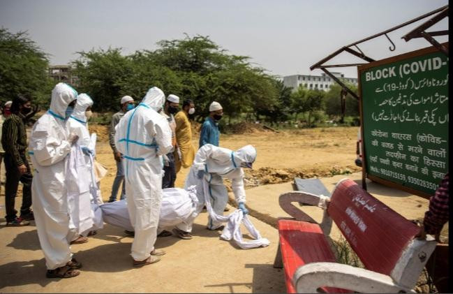 Các nhân viên y tế và người nhà đưa thi thể một nạn nhân COVID-19 ra nghĩa trang ở Delhi ngà 28/4. (Ảnh: Reuters)