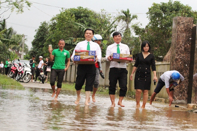 Ông Hồ Huy Chủ tịch Tập đoàn Mai Linh (thứ 2 từ trái qua) trực tiếp trao quà, hỏi thăm người dân vùng lũ. Ảnh: Sóng Nghệ