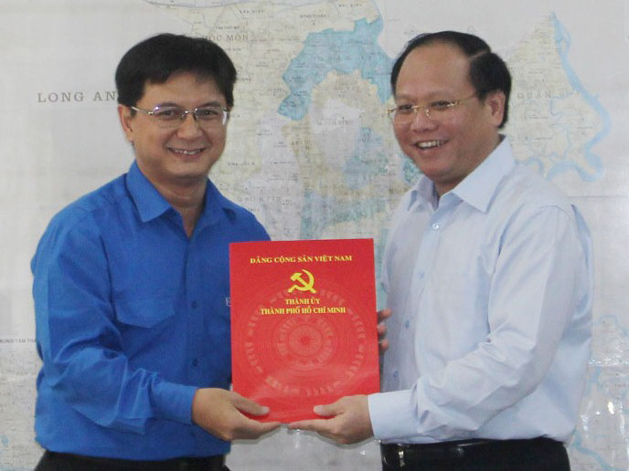 Ủy viên Trung ương Đảng, Phó Bí thư Thường trực Thành ủy TPHCM Tất Thành Cang (bìa phải) trao quyết định điều động Bí thư Thành Đoàn làm Bí thư Quận ủy Thủ Đức. Ảnh: Ngọc Tuyết.