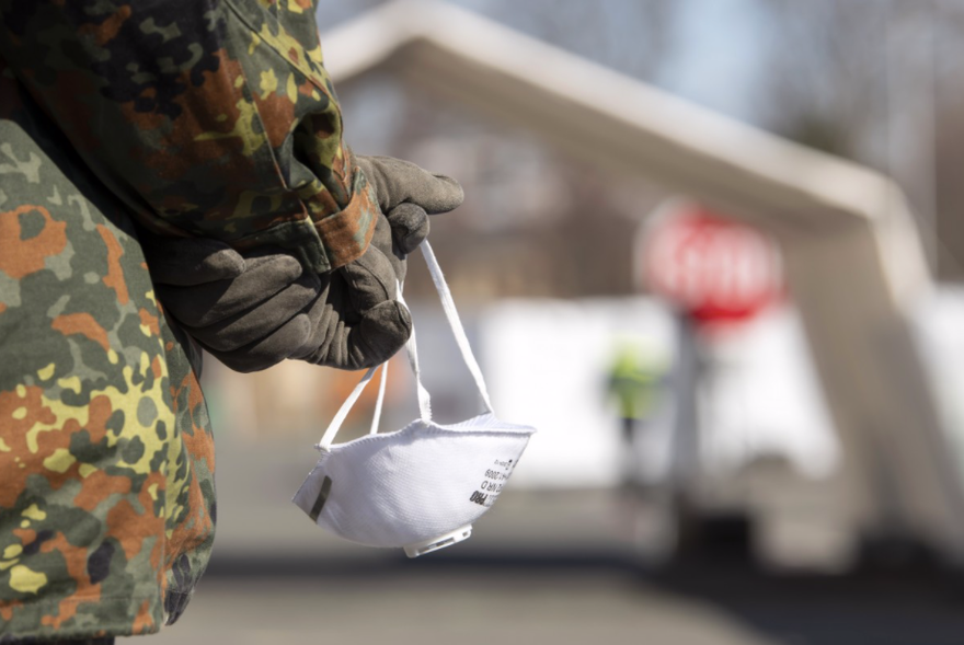 Một thành viên lực lượng vũ trang Đức cầm trên tay chiếc khẩu trang 3M. (Ảnh: AP)