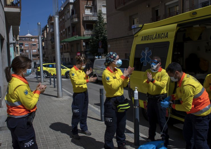 Các nhân viên y tế Tây Ban Nha khử trùng tay sau khi vận chuyển một bệnh nhân hôm 6/4. (Ảnh: AP)