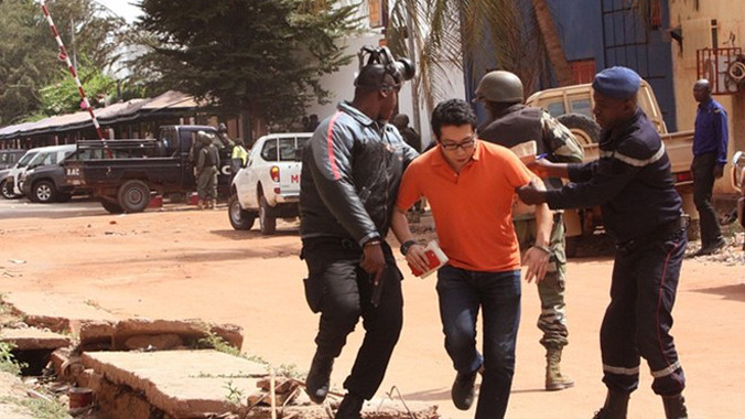 Cảnh sát hộ tống một con tin rời khỏi hiện trường vụ bắt cóc. Ảnh: Guardian.