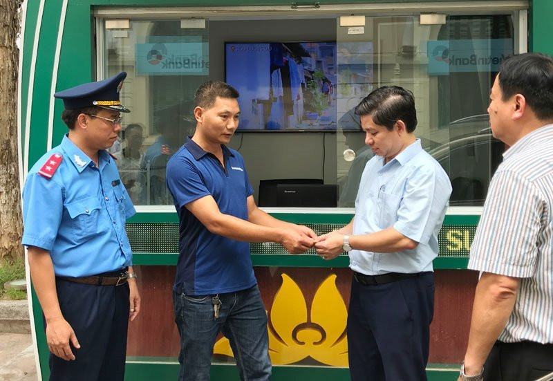 Đại diện Đội TTGT quận Ba Đình chứng kiến tài xế vi phạm trao tiền thu cao trả lại hành khách ​