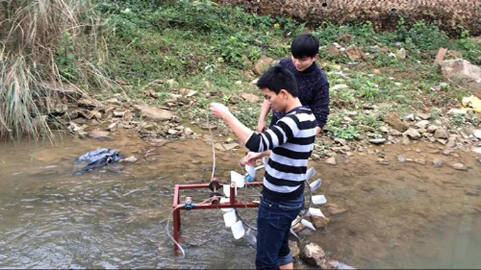 Hai "nhà phát minh" đang thử chạy thiết bị đưa nước lên cao không cần dùng điện tại một con suối.