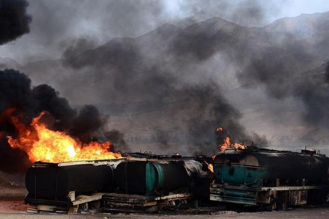 Các xe tải chở dầu của IS tại Syria cháy sau một cuộc không kích của Mỹ trong tháng 11. Ảnh: New York Times.