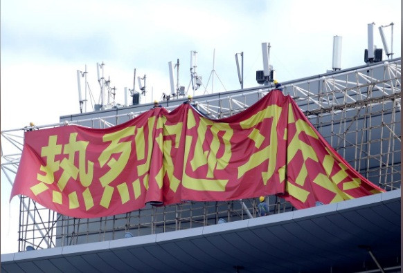 Các công nhân đang treo biểu ngữ chào mừng Chủ tịch Trung Quốc Tập Cận Bình. (Ảnh: Reuters)