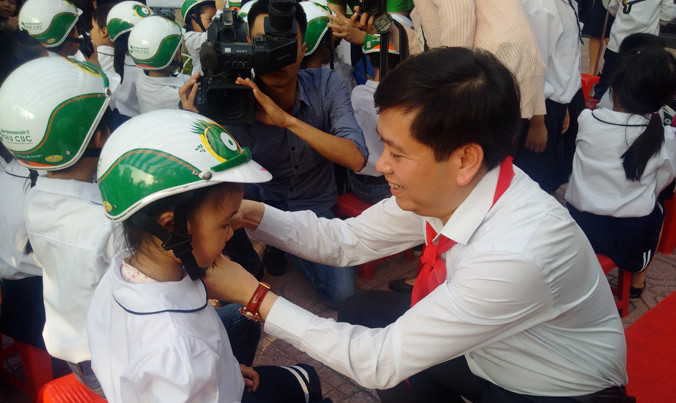 Bí thư T.Ư Đoàn, Chủ tịch Hội đồng Đội T.Ư Nguyễn Long Hải tặng mũ bảo hiểm cho học sinh tại trường Tiểu học Dịch vọng B, Cầu Giấy.