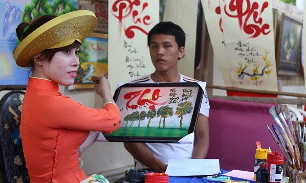 Một cô đồ đang múa bút. Ảnh: Sáu Nghệ