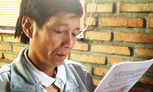 Ông Lé với quyết định bồi thường oan sai vừa nhận được. Ảnh: Phúc Nguyên