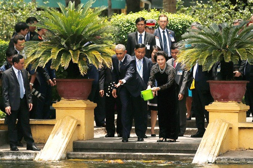 Tổng thống Mỹ Obama cùng Chủ tịch Quốc hội Kim Ngân cho cá ăn tại khu nhà sàn Hồ Chủ tịch. Ảnh: Reuters